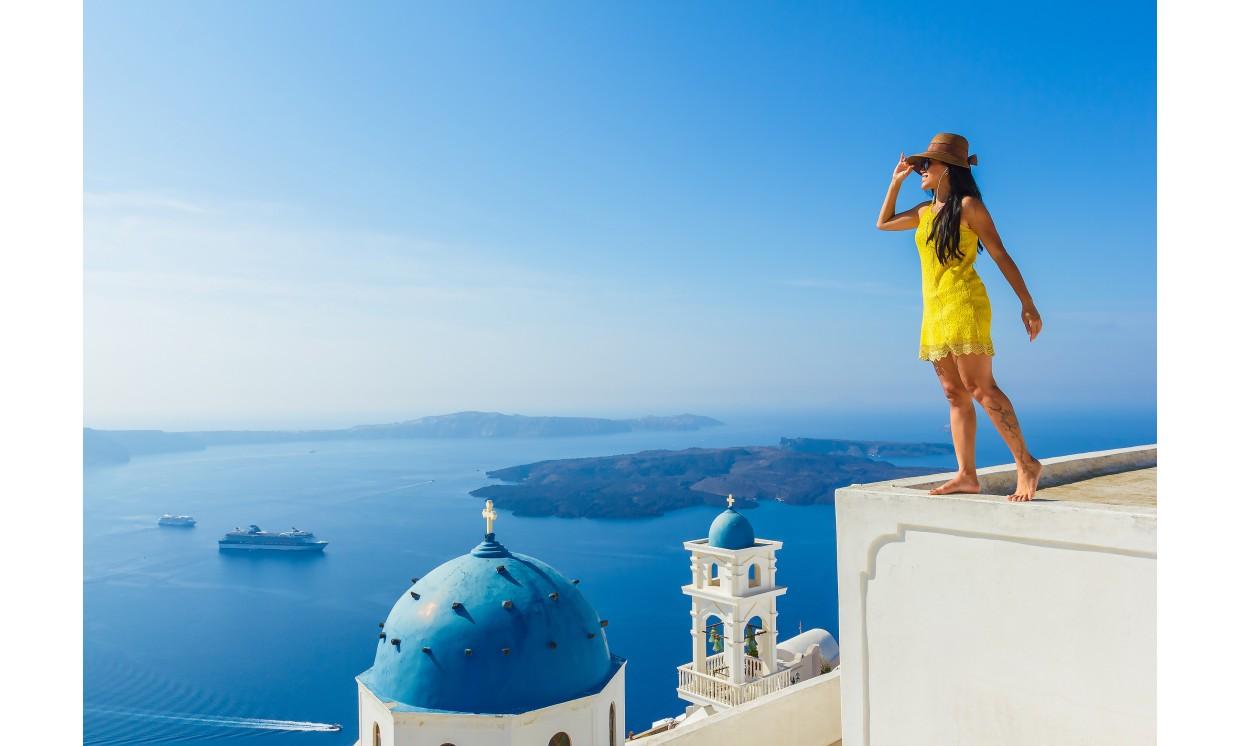 building female tourist enjoys breathe view santorini