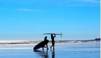 man and womans silhouette on blue background beach