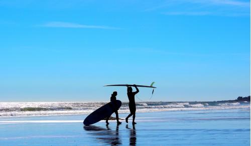 man and womans silhouette on blue background beach